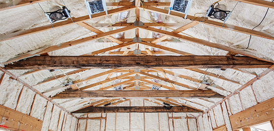 Spray foam insulation newly installed in a building's walls and ceiling