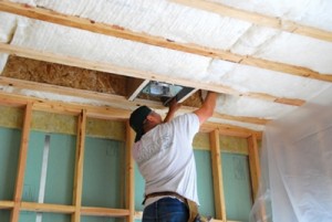 A technician installing insulation in a roof