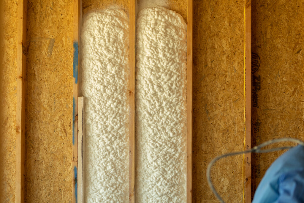 Spray foam insulation being installed into a wall of a new residential building